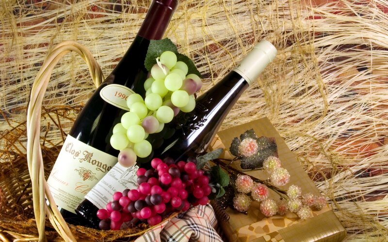 Wine bottles with grapes in basket