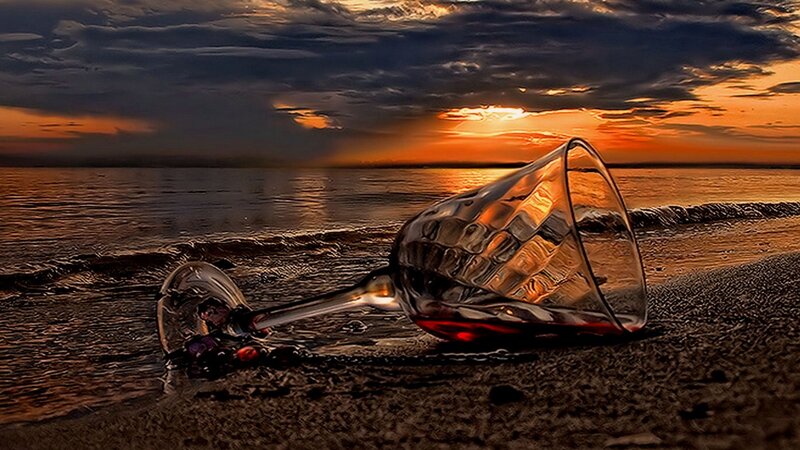 wine glass on beach at sunset