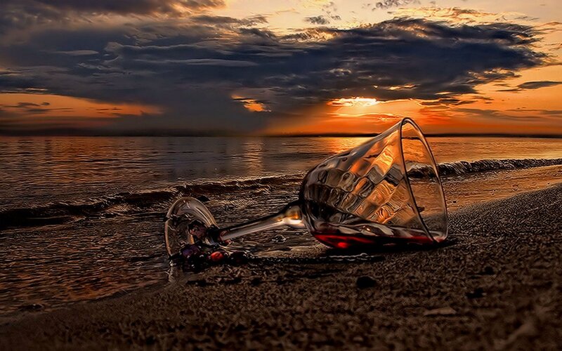 wine glass on beach at sunset