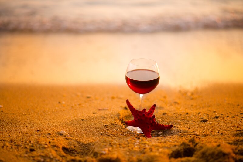 wine glass on beach at sunset