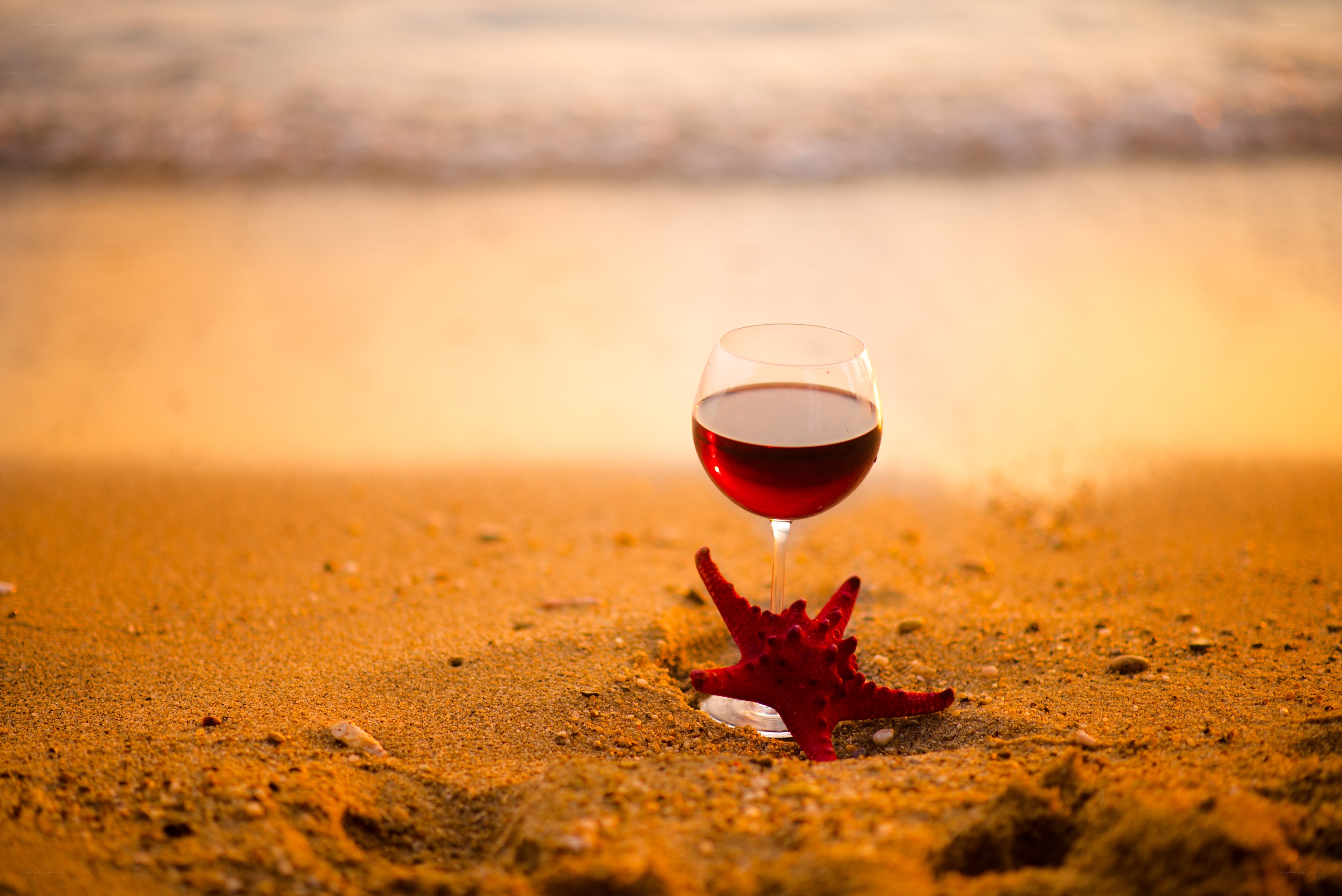 wine glass on beach at sunset