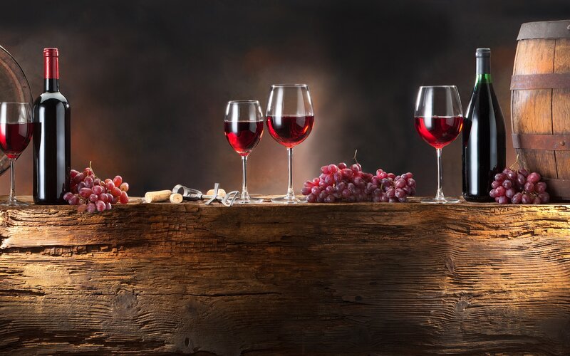 Wine glasses and grapes on wood