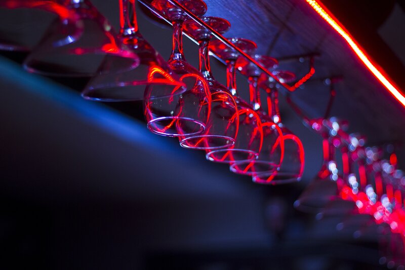 Wine glasses under neon lights