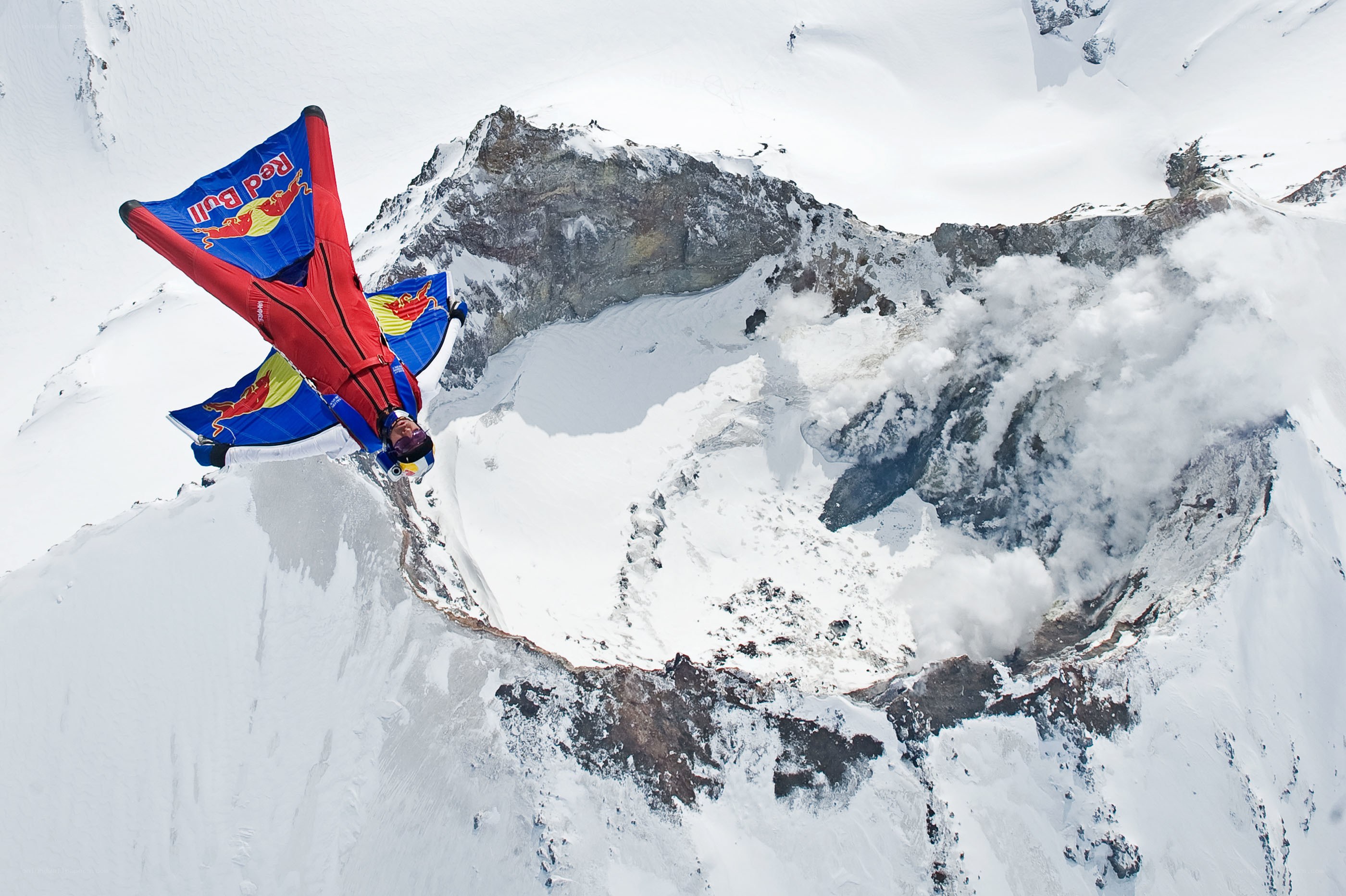 Wingsuit flyer over snowy mountain
