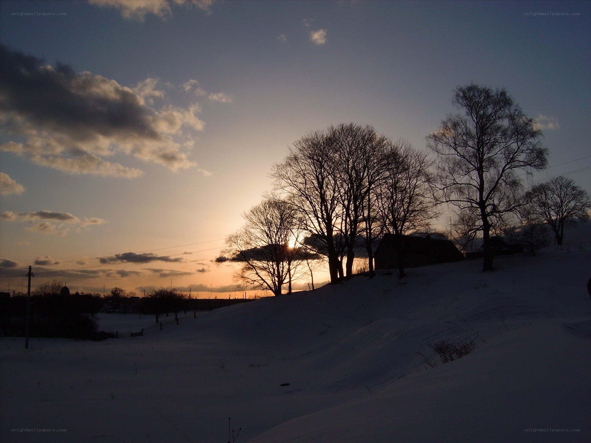 Winter sunset over snowy hill