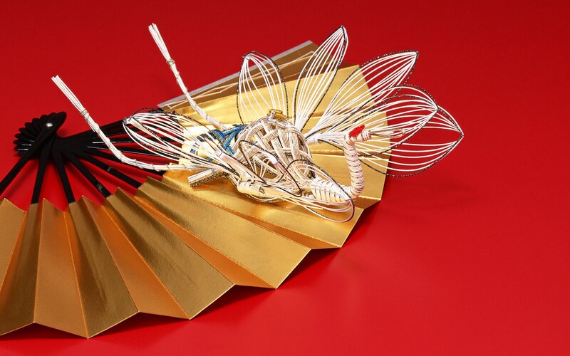 Wire crane sculpture on golden fan