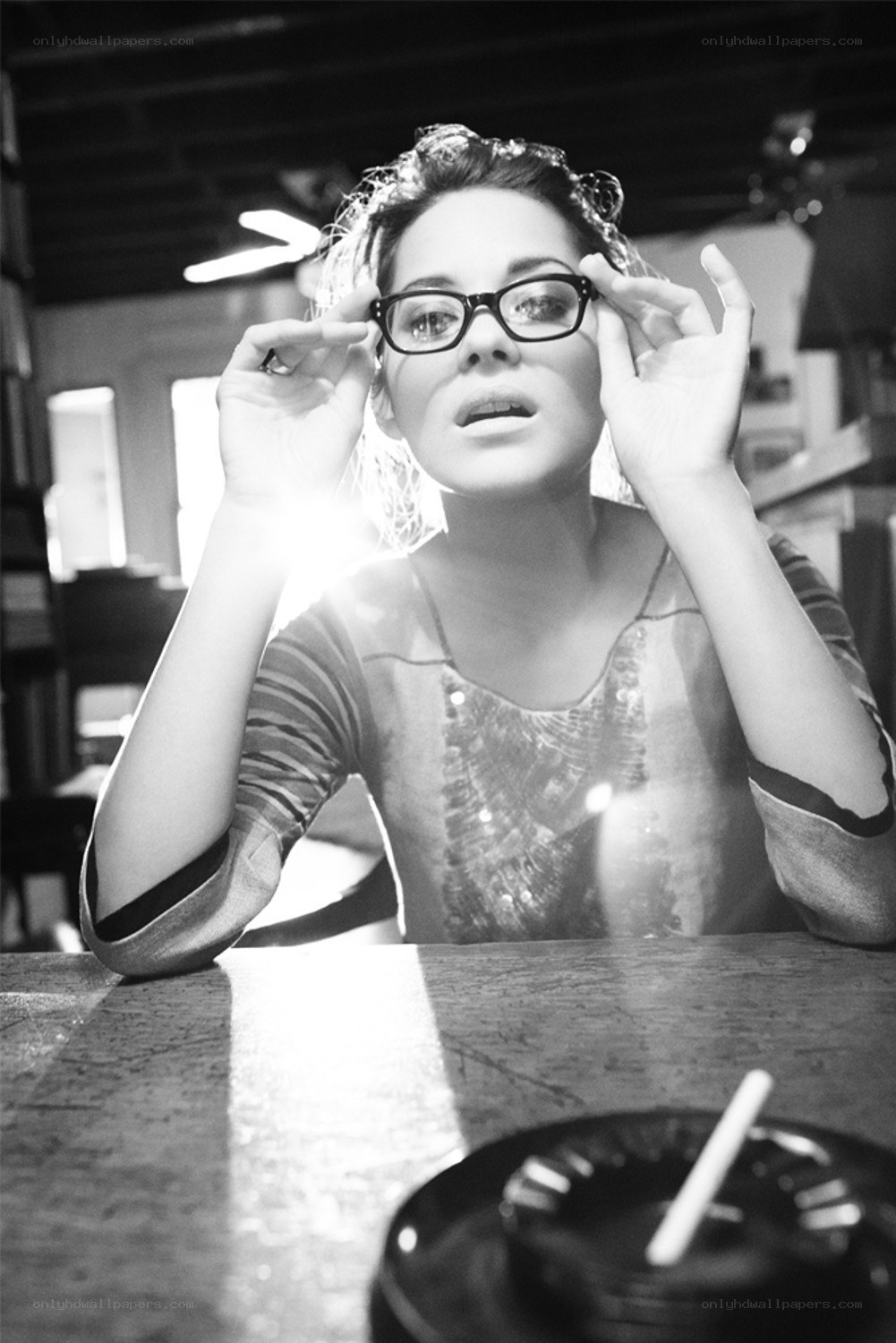 woman adjusting glasses at table