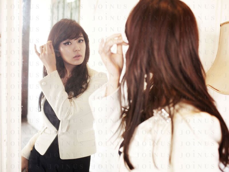 woman adjusting hair in mirror