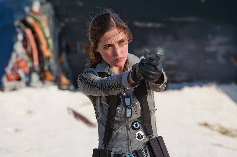 Woman aiming a gun in desert
