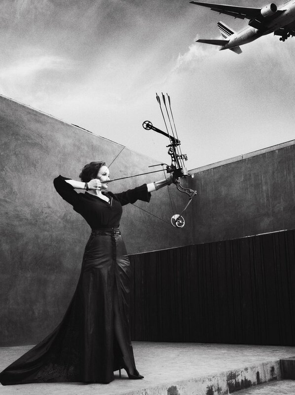 Woman aiming bow at airplane