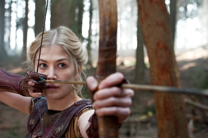 Woman aiming bow in forest