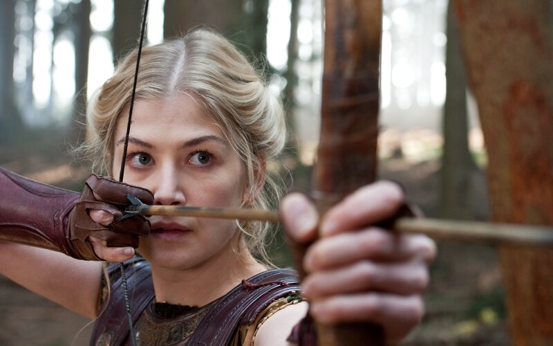 woman aiming bow in forest