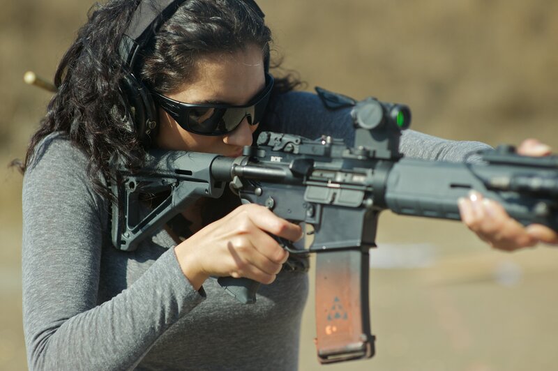 woman aiming rifle at range