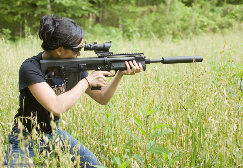 woman aiming rifle in field