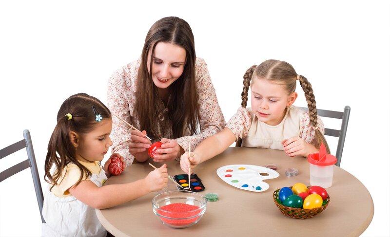 woman and children painting eggs