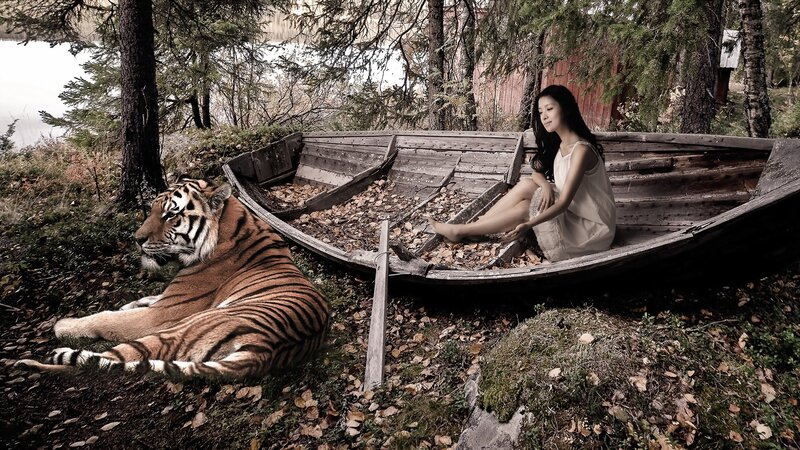 Woman and tiger in a boat