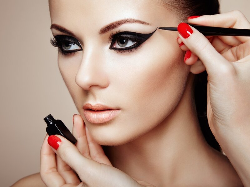 Woman Applying Eyeliner — Beige