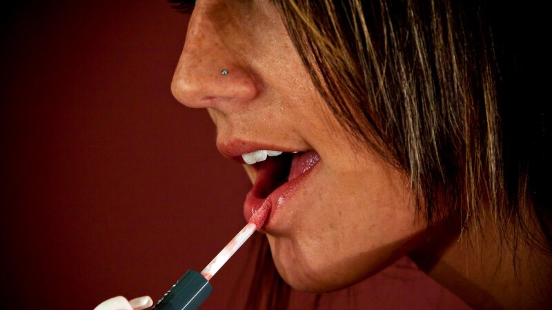 Woman Applying Lip Gloss — Red