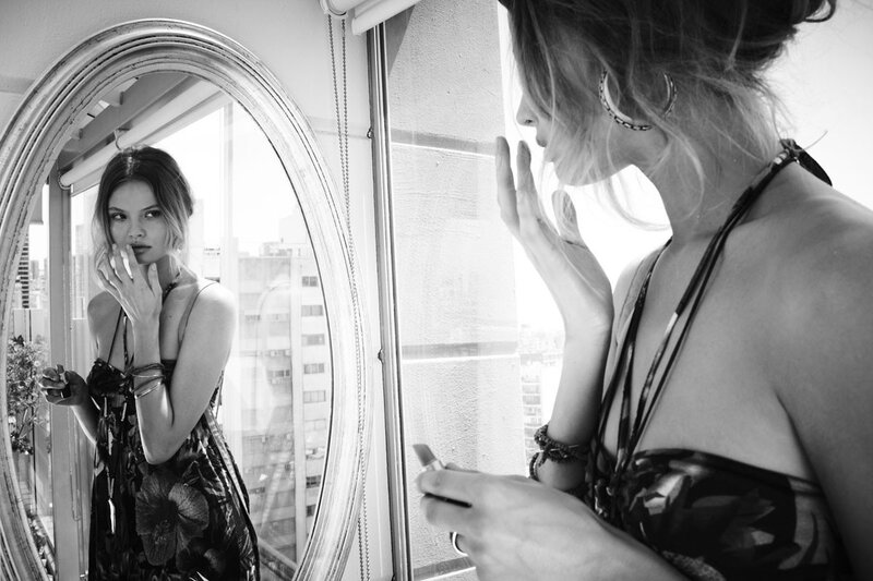 woman applying lipstick in mirror
