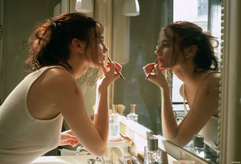 woman applying lipstick in mirror