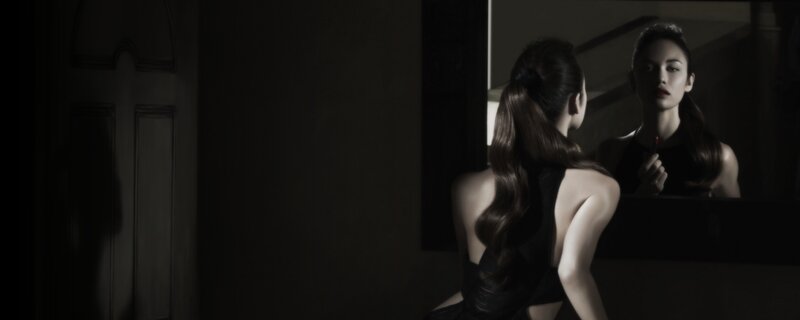 woman applying lipstick in mirror