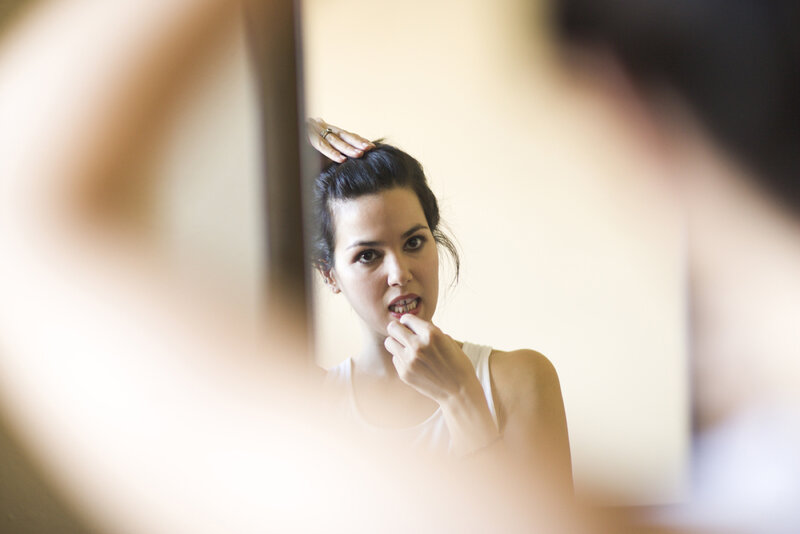 woman applying lipstick in mirror