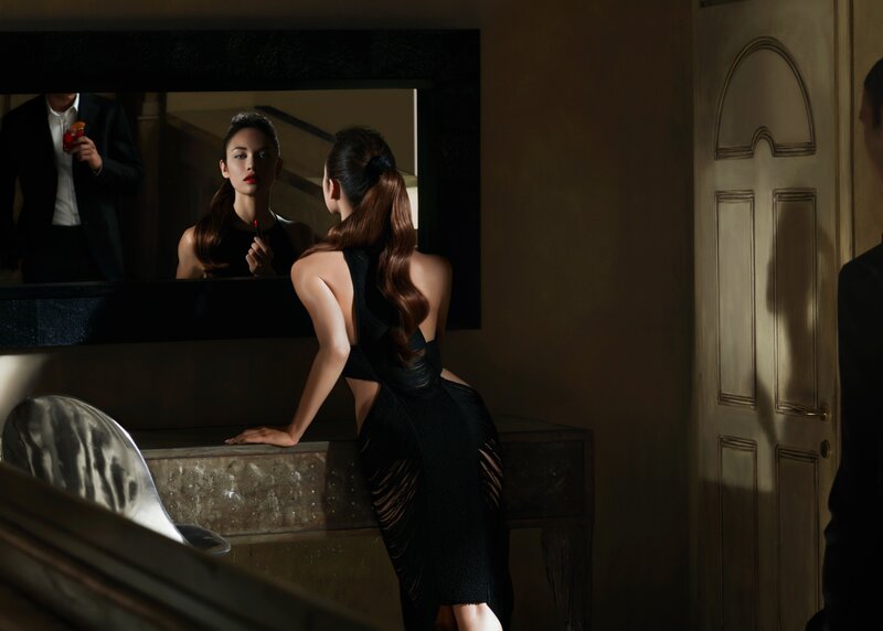 woman applying lipstick in mirror