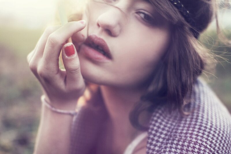 woman applying lipstick outdoors