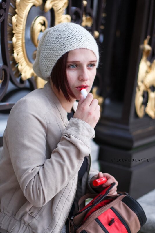 woman applying lipstick outdoors
