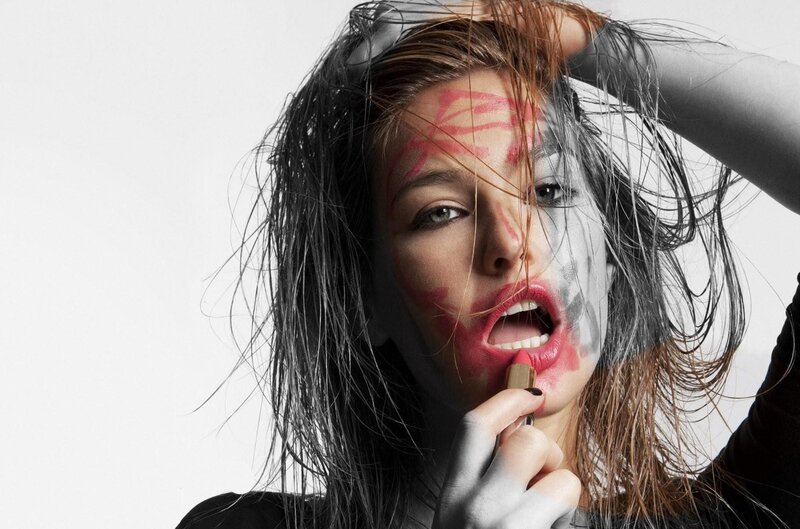 woman applying lipstick with face paint
