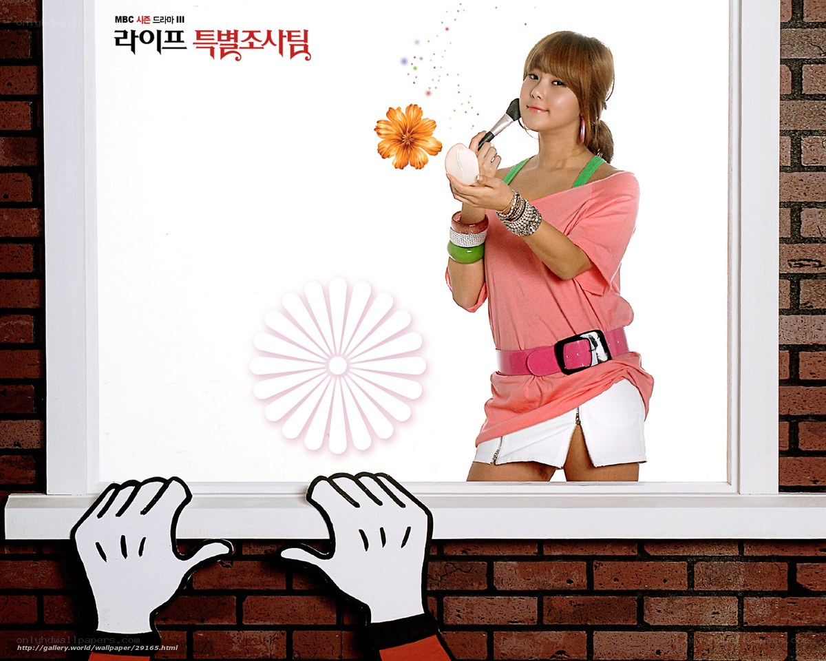 woman applying makeup by window