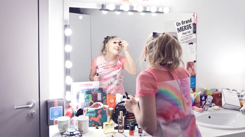 woman applying makeup in bathroom