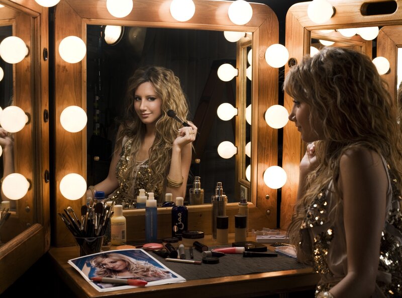 woman applying makeup in dressing room