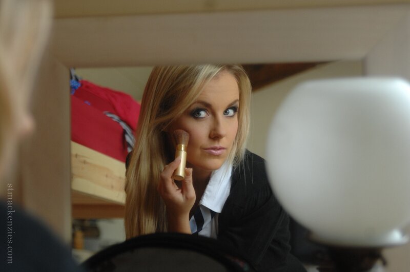 woman applying makeup in mirror