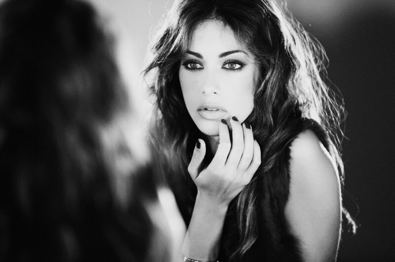 woman applying makeup in mirror