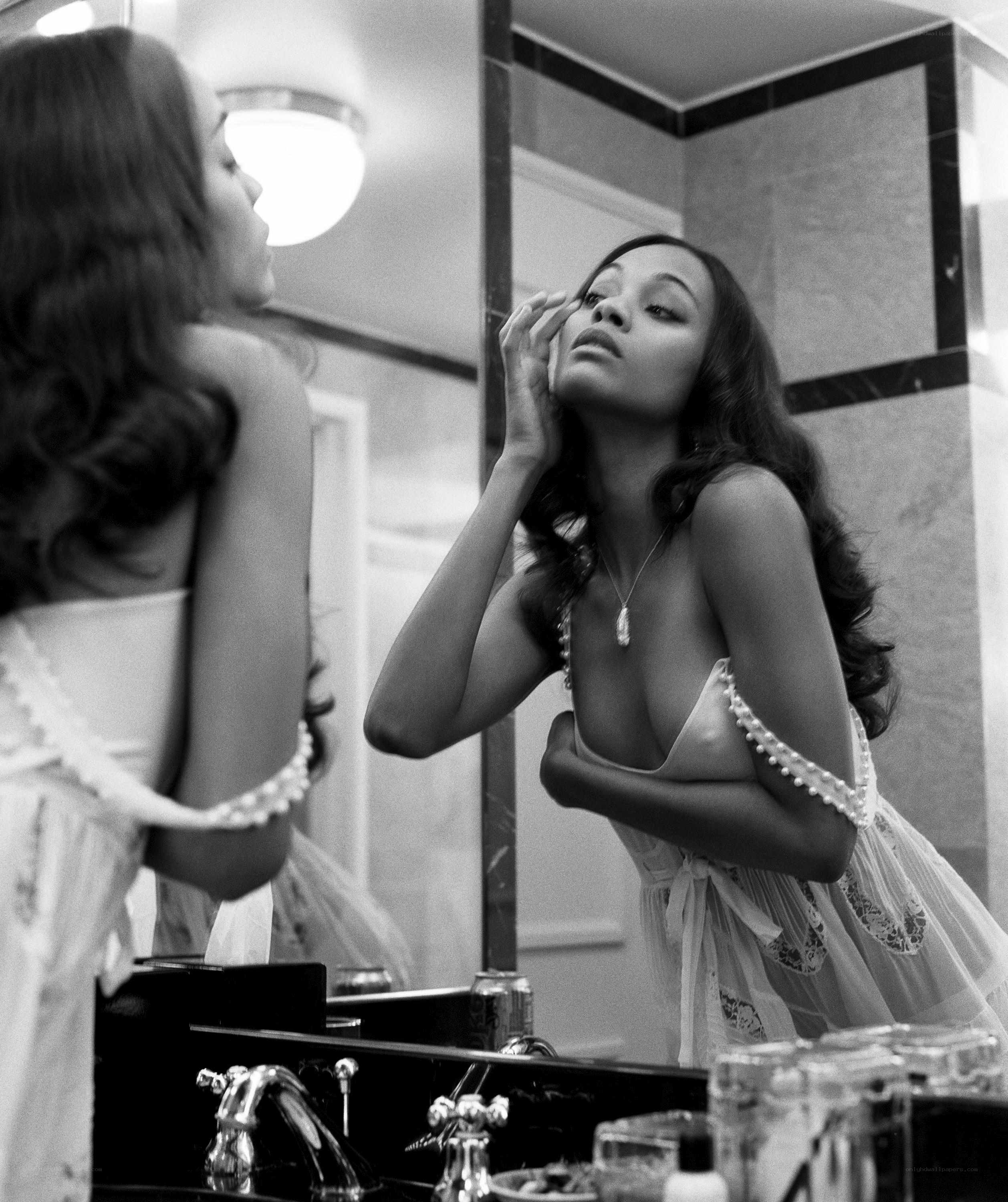 woman applying makeup in mirror