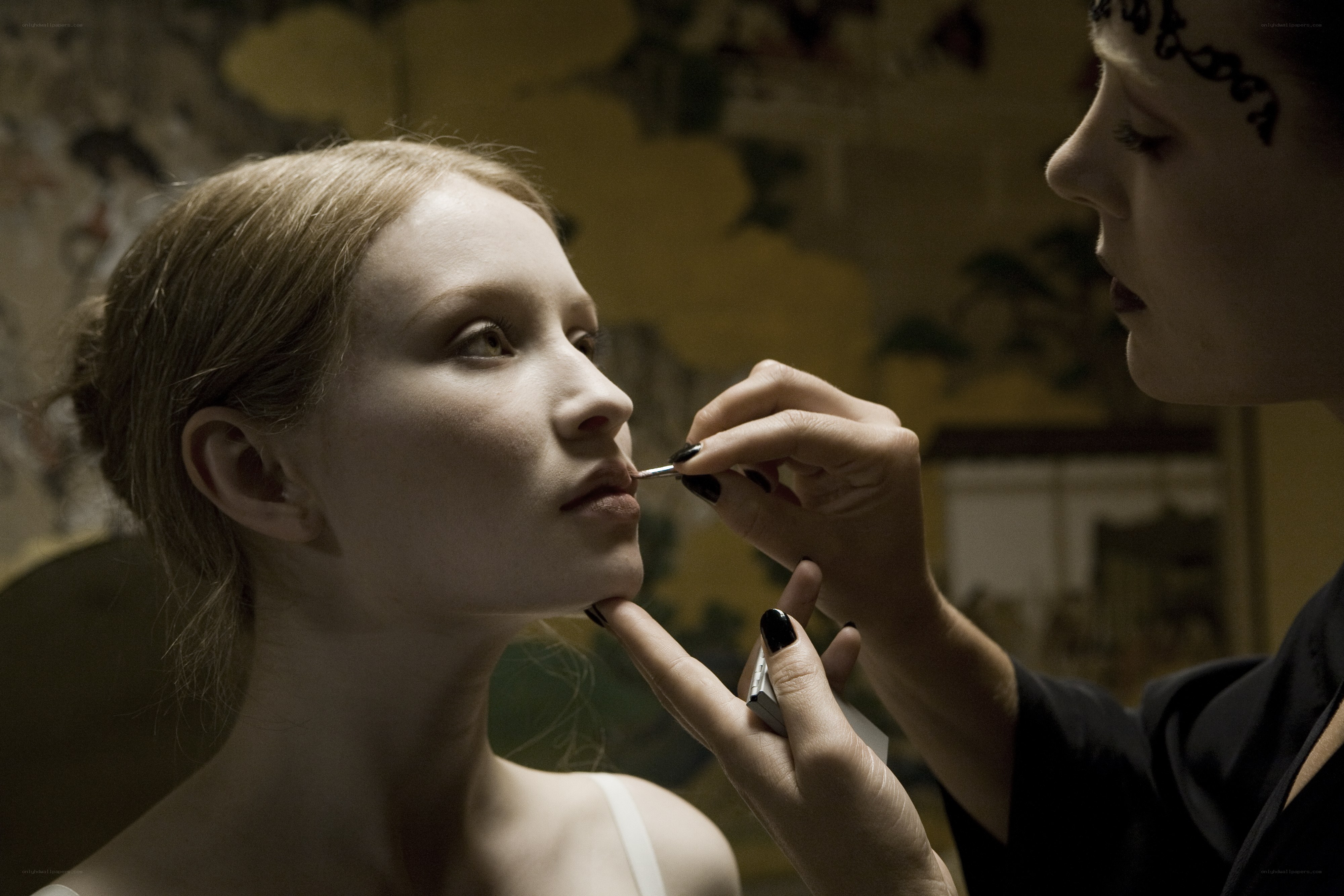 woman applying makeup to another