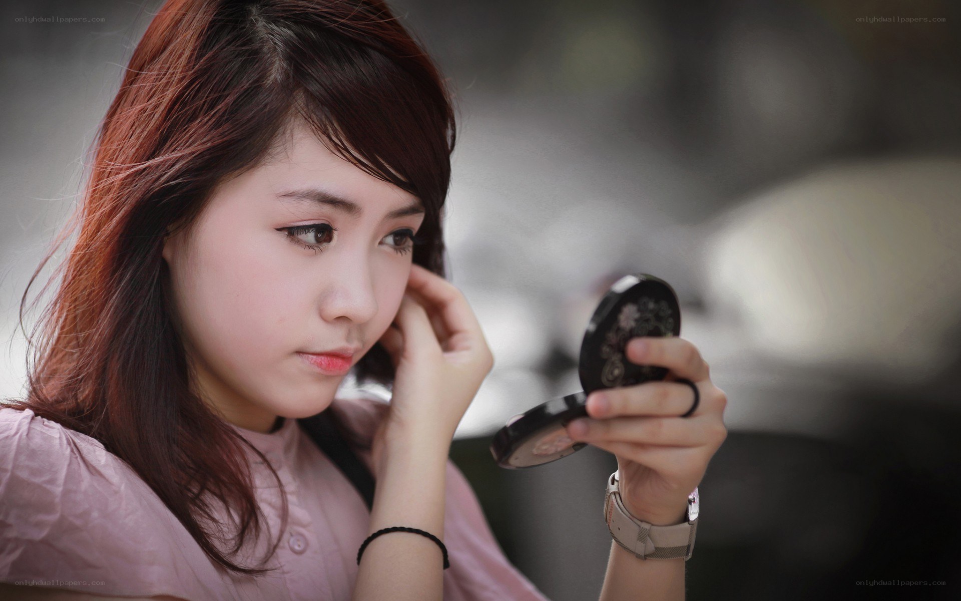 woman applying makeup with compact mirror