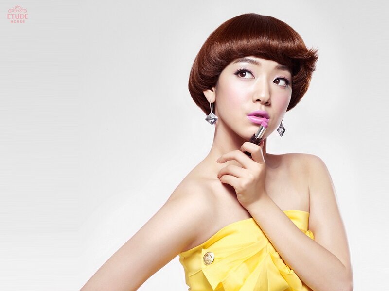 woman applying pink lipstick