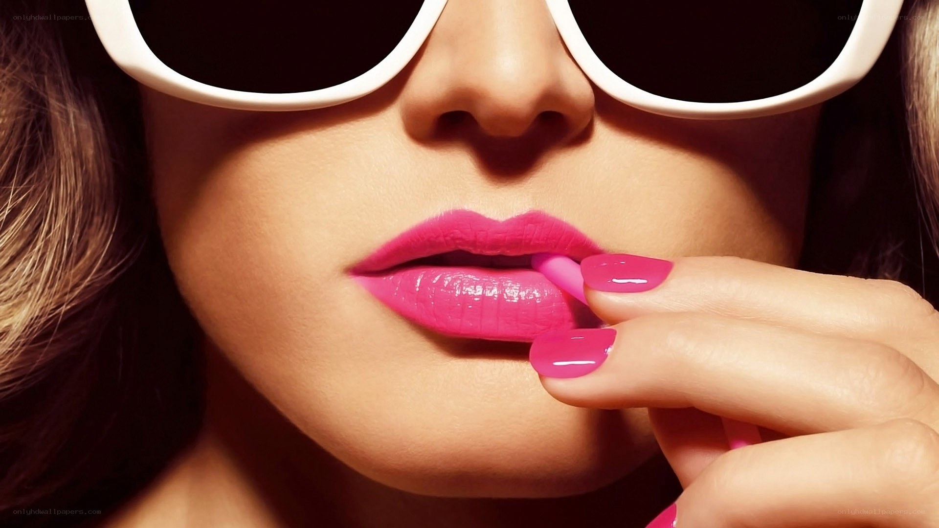 woman applying pink lipstick