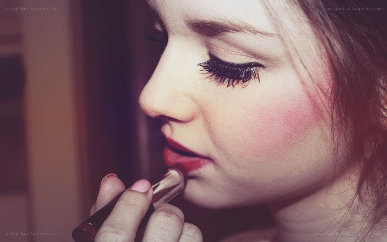 woman applying red lipstick