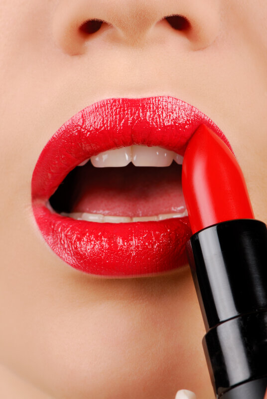 woman applying red lipstick