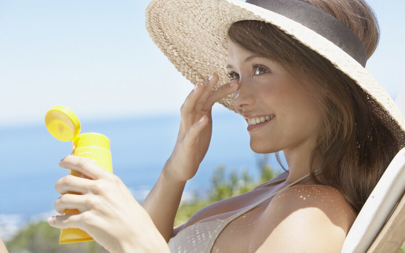 Woman applying sunscreen at beach
