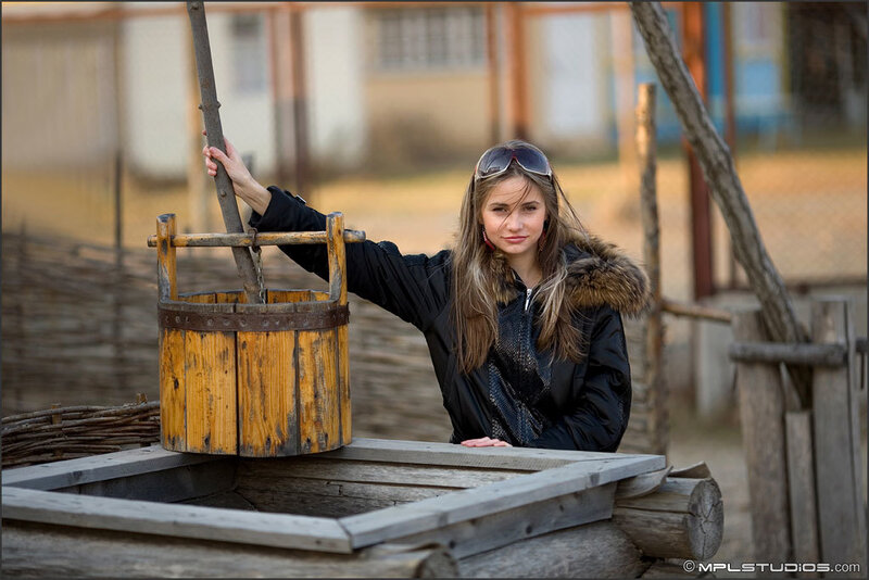 woman at a well with wooden bucket