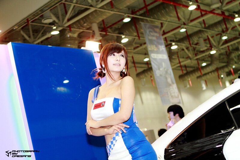 Woman at auto show in blue and white dress