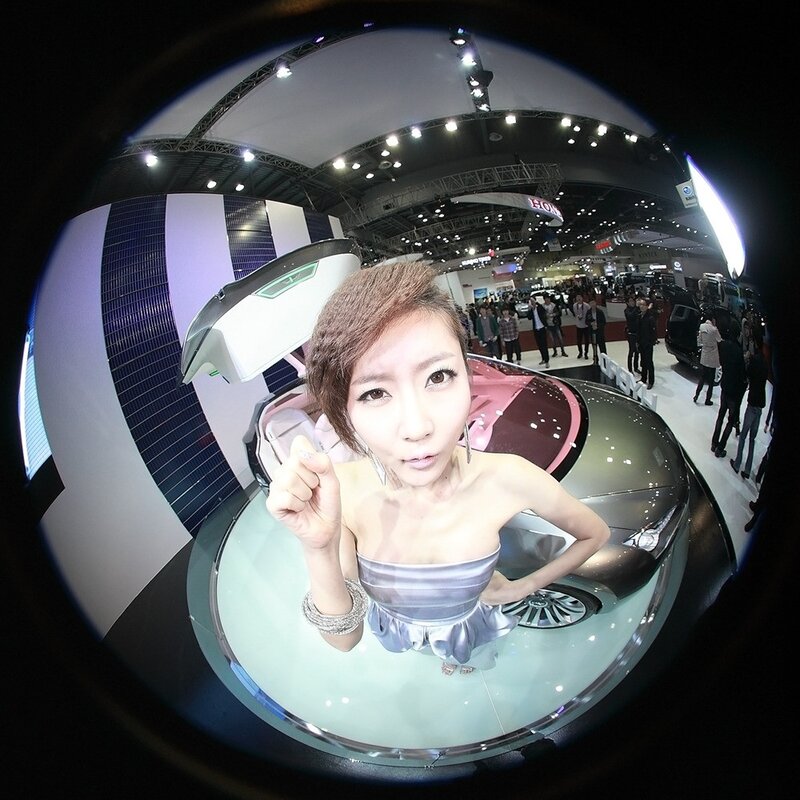 Woman at auto show with fish-eye lens