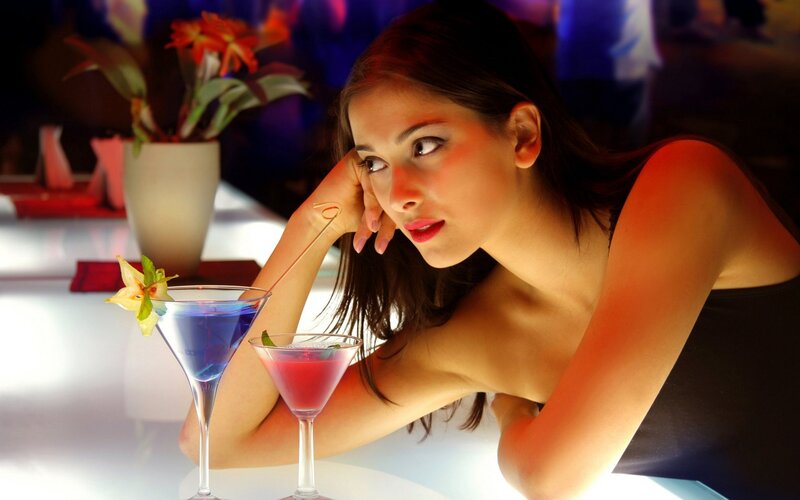 woman at bar with cocktails