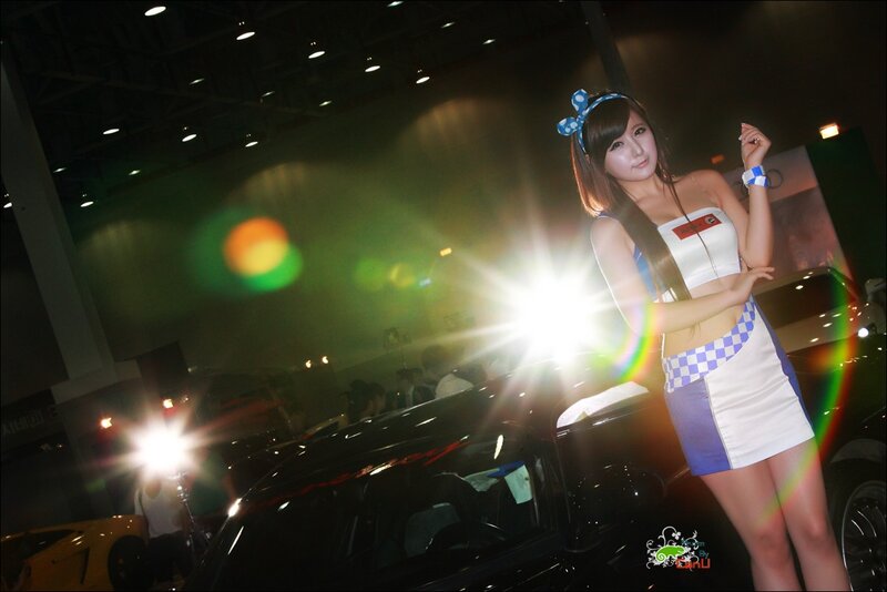 Woman at car show with bright lights