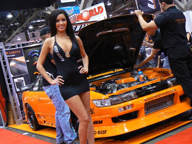 Woman at car show with orange sports car