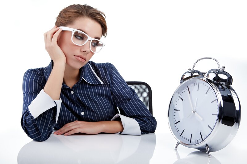 woman at desk with alarm clock